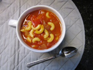 A bowl of tomato macaroni soup.