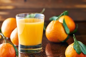 Fresh oranges with a glass of orange juice.