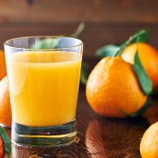 Fresh oranges with a glass of orange juice.