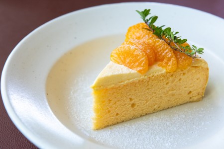 A slice of orange cake on a plate.