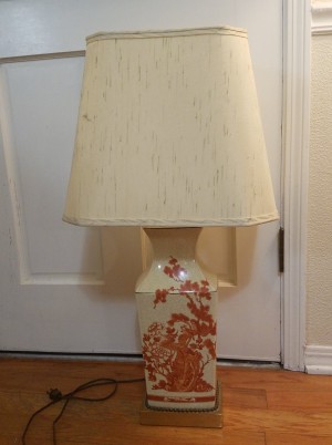 A cream colored lamp with red decorations.