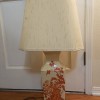 A cream colored lamp with red decorations.
