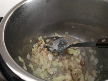 Sauteeing onions in the bottom of an Instant Pot.