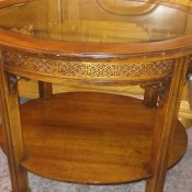 A round Brandt end table with a glass top.