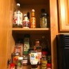 A cabinet containing spices and other cooking ingredients.