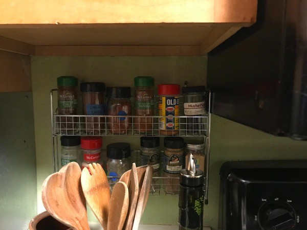 A small spice rack underneath a cabinet.