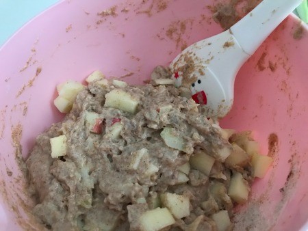Mixing the apples into the muffin batter.