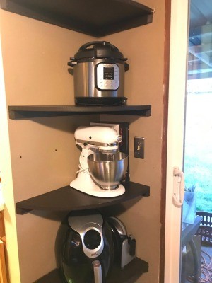 Appliances stored on a corner shelf.