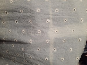 A faded line in the middle of a light colored fabric.