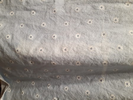A faded line in the middle of a light colored fabric.
