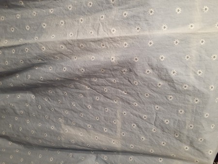 A faded line in the middle of a light colored fabric.