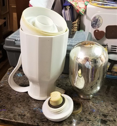 A coffee carafe that has been taken apart.