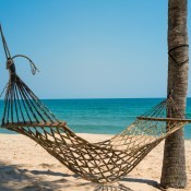 A hammock on a sandy beach.