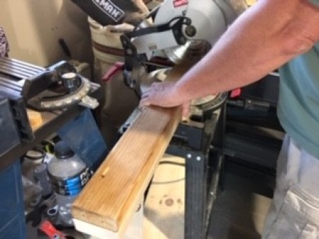 Cutting the pieces of wood with a saw.