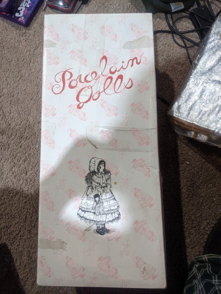 A box containing a porcelain doll.