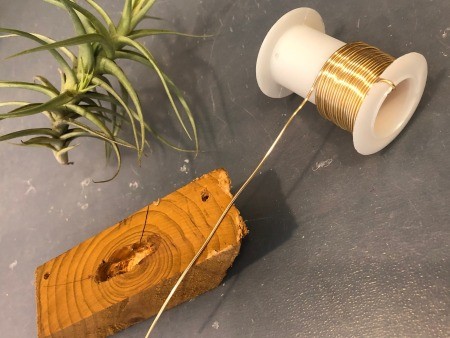 Attaching wire to the wooden piece.