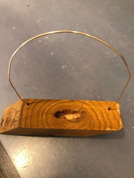 Attaching wire to the wooden piece.