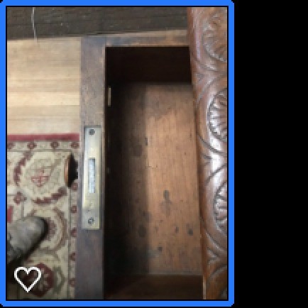 The open drawer of an old wooden desk.