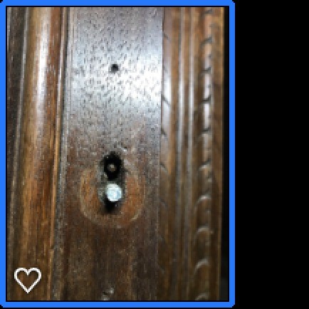 The keyhole in an old wooden desk.