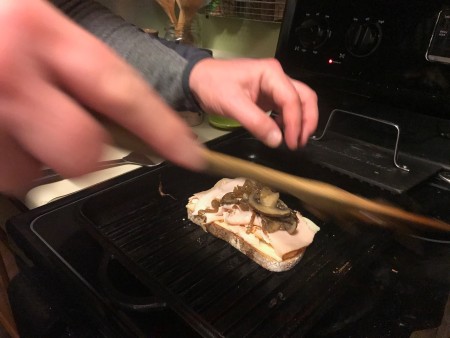 Placing the sandwich on the grill pan.