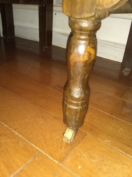 The leg of an old wooden desk.