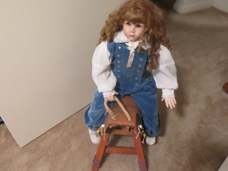 An old doll with long reddish brown hair.