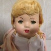 An old doll with blonde hair.