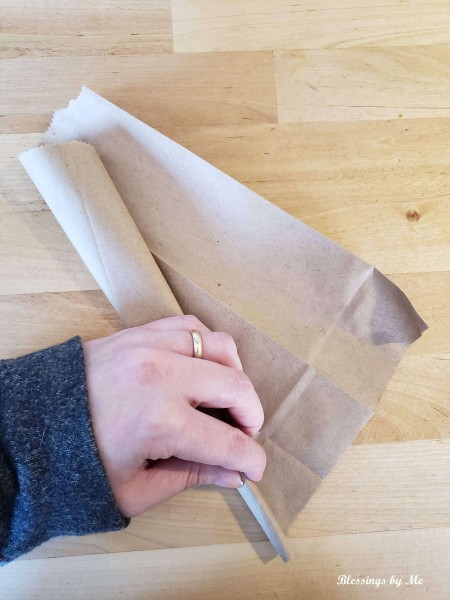 Rolling the folded piece of paper.