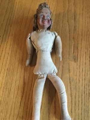An old doll with no clothing.