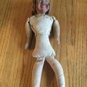An old doll with no clothing.