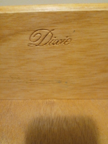 The Dixie marking on a wooden nightstand.