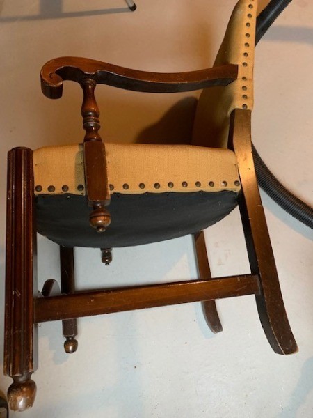 A chair with wooden arms and legs.