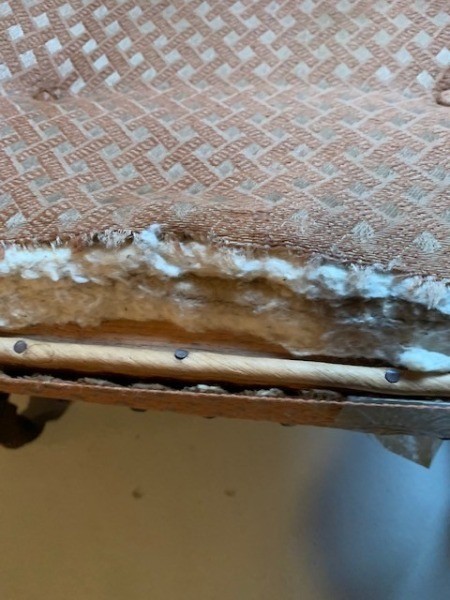The underside of an old upholstered chair.