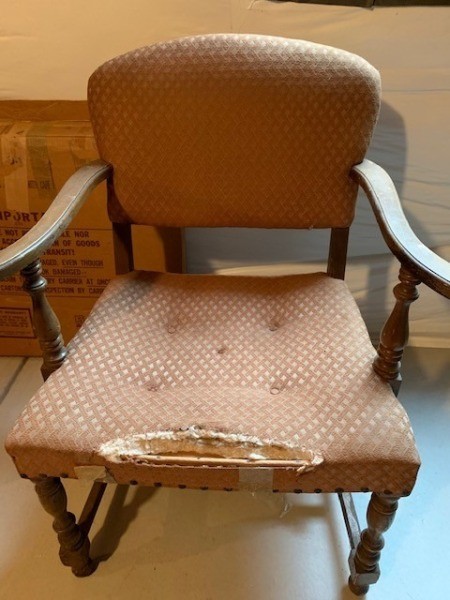 A chair with wooden arms and legs.