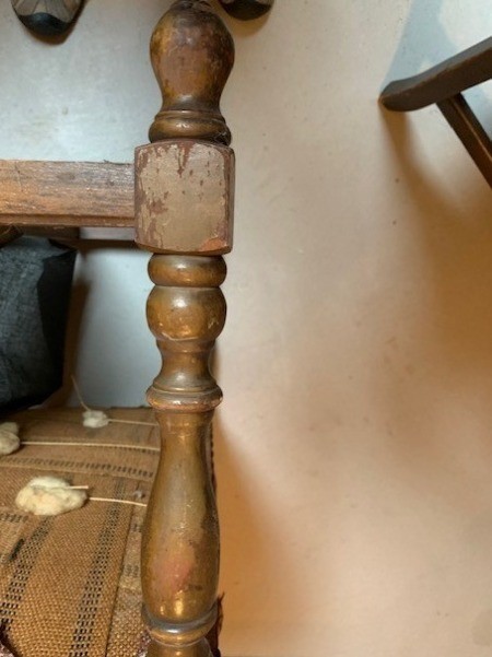 A chair with wooden arms and legs.