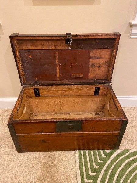 A wooden trunk with the lid opened.