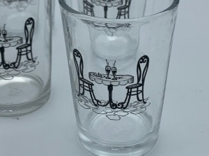 Small juice glasses with a drawing of a table with two chairs.