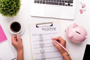 A wedding budget list on a clipboard.