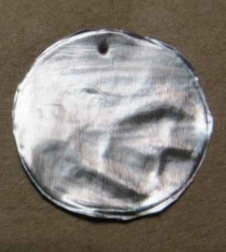 A circular piece with a hole in the top.