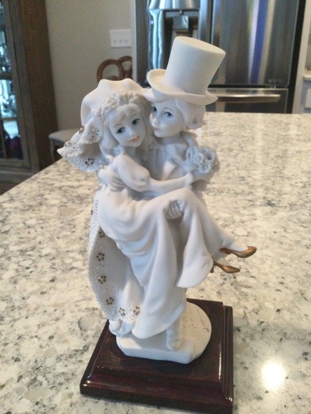 A figurine of two children getting married.
