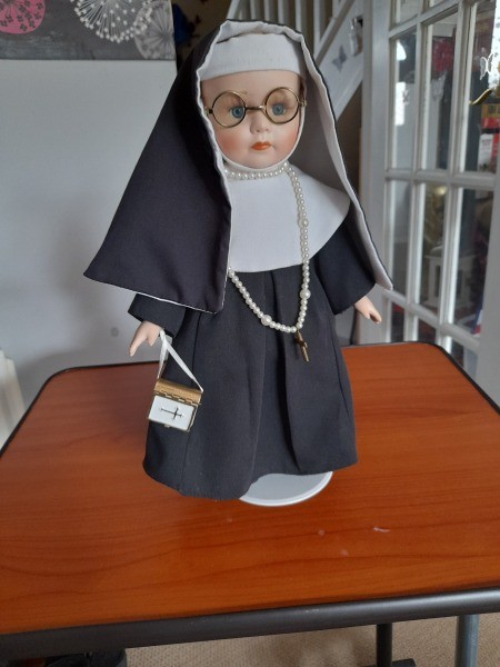 A porcelain doll dressed as a nun.