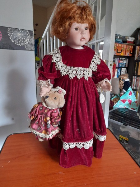 A porcelain doll in a red outfit.