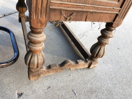 The legs of an old wooden desk.