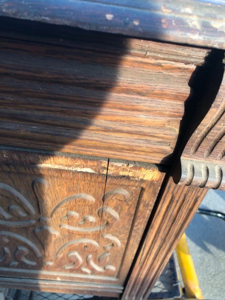 The carved side of a wooden desk.