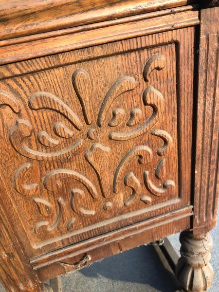 A carved panel of a wooden desk.