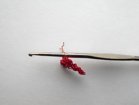 Using a crochet hook to close the hanging loop.