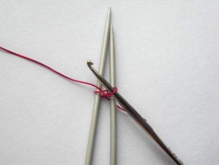 Using crochet hooks to knit the wire together.