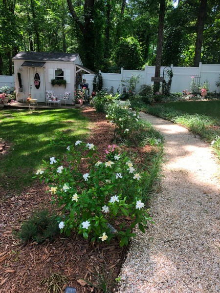 A garden path with flowers next to it.