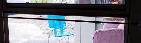 A chair turned toward the uncovered window.