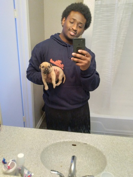 A man holding a small puppy.